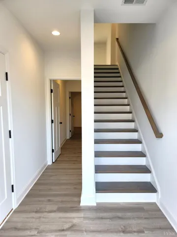 a view of a hallway with wooden floor and entryway
