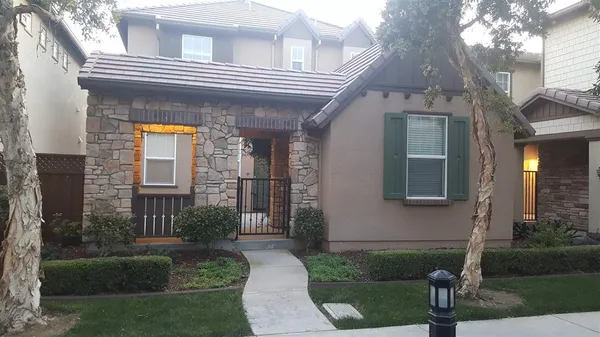 a view of a house with brick walls and a yard in front of it