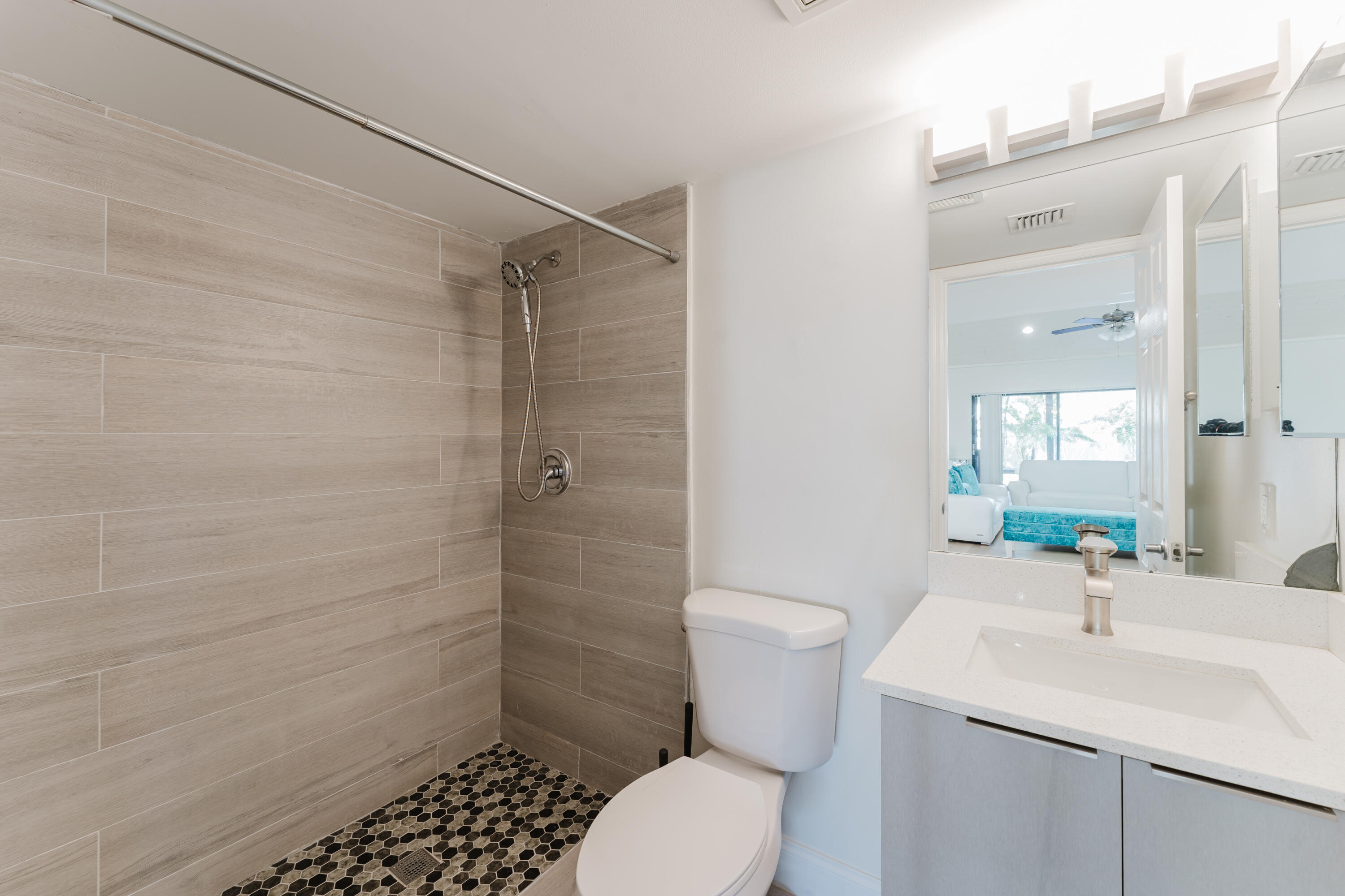 665 Jeffery Street Boca Raton, FL 33487 - Photo 17 of 44 a bathroom with a sink toilet a mirror and shower