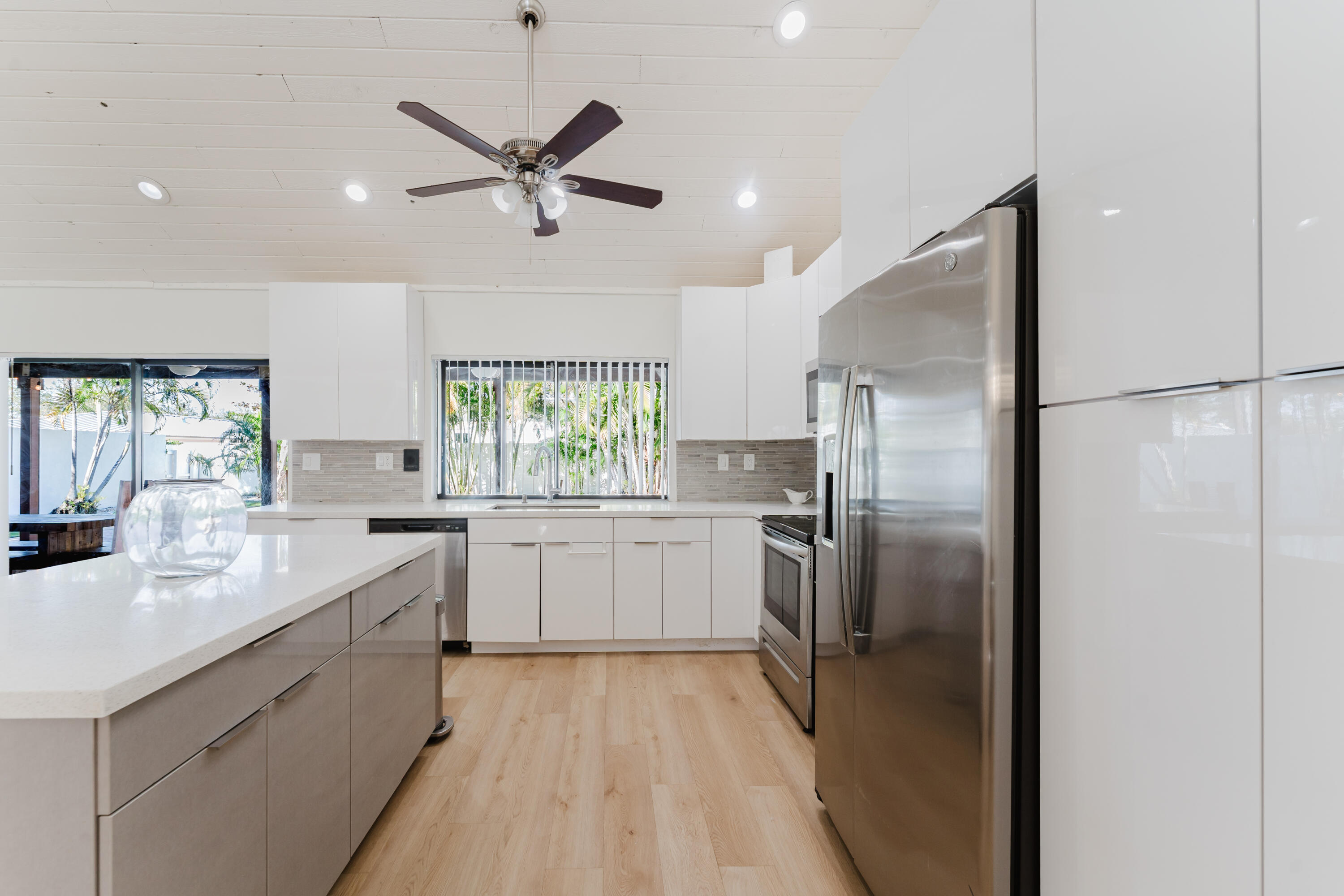 665 Jeffery Street Boca Raton, FL 33487 - Photo 10 of 44 a kitchen with white cabinets and stainless steel appliances