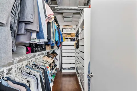 a view of walk in closet with clothes and shoes