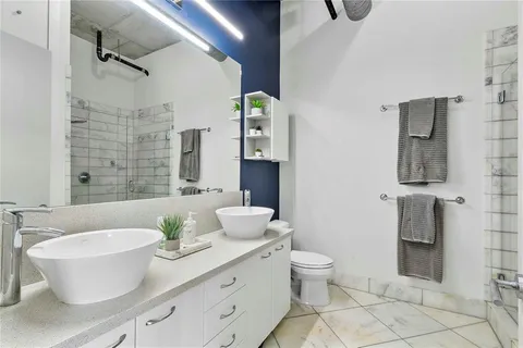 a bathroom with a double vanity sink mirror and toilet