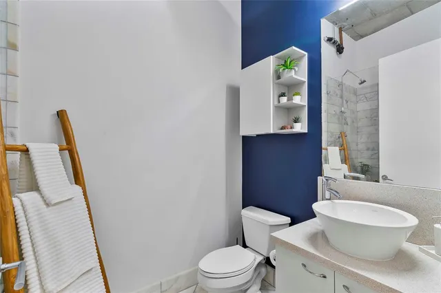 a white toilet sitting next to a bathroom sink and a mirror