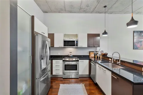 a kitchen with stainless steel appliances a stove a sink and a refrigerator