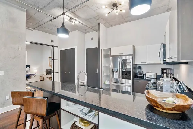 a room with stainless steel appliances kitchen island granite countertop furniture and a kitchen view