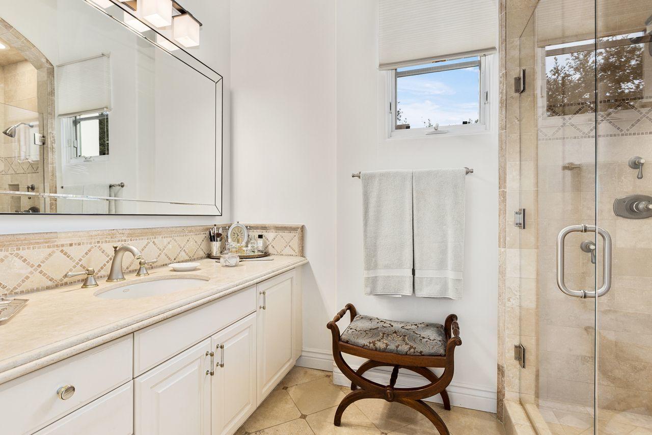 492 Monarch Lane Montecito, CA 93108 - Photo 33 of 58 a bathroom with a granite countertop sink a mirror a vanity and a shower