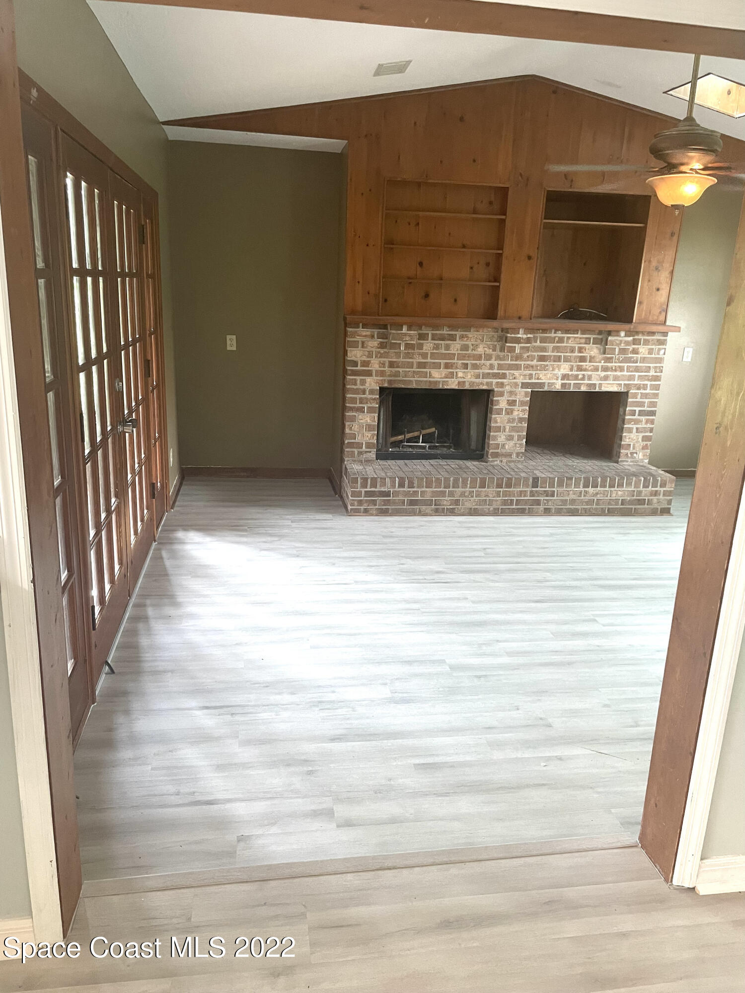 590 Rheine Road Northwest Palm Bay, FL 32907 - Photo 17 of 19 a view of empty room with wooden floor and fireplace