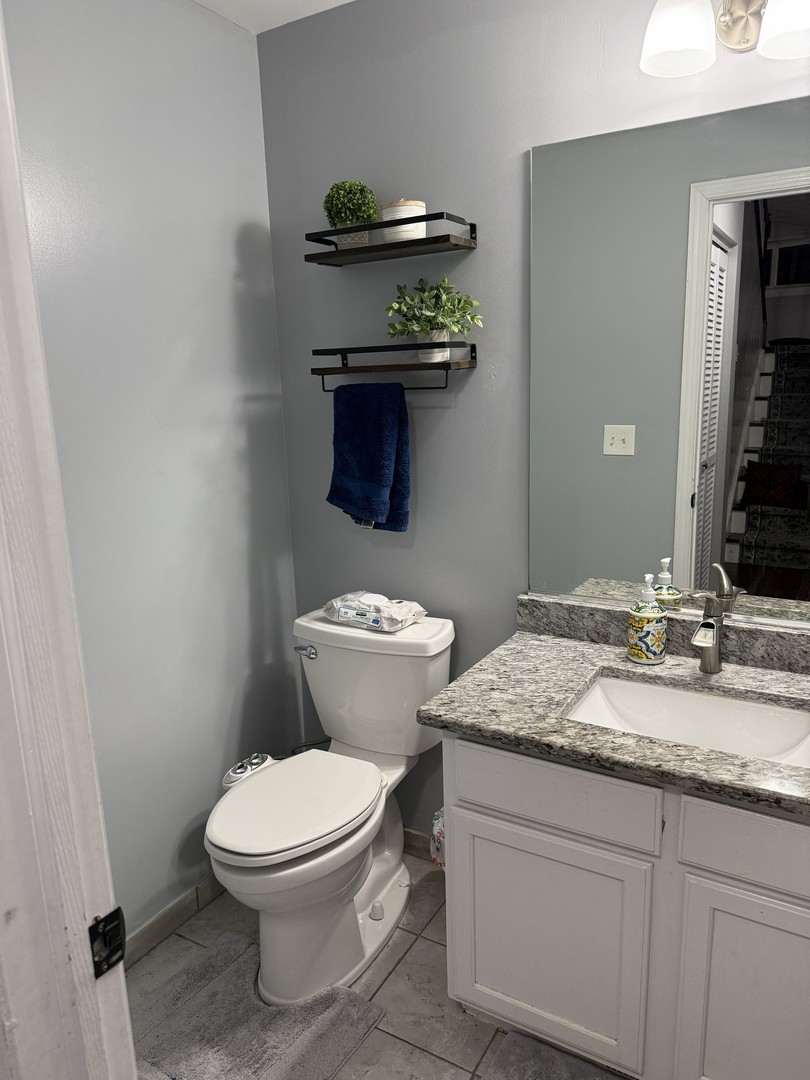 689 Shannon Drive Romeoville, IL 60446 - Photo 12 of 24 a bathroom with a granite countertop toilet sink and mirror