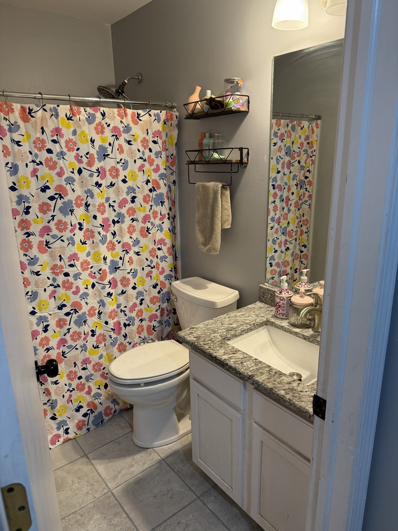 689 Shannon Drive Romeoville, IL 60446 - Photo 17 of 24 a bathroom with a granite countertop toilet a sink and a shower