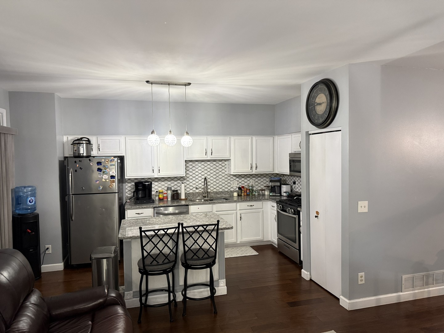 689 Shannon Drive Romeoville, IL 60446 - Photo 5 of 24 a kitchen with stainless steel appliances a refrigerator a stove a dining table and chairs with wooden floor