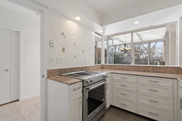 a kitchen with granite countertop a sink stove and cabinets