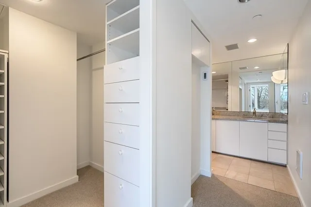a bathroom with a granite countertop sink a toilet a large mirror and vanity
