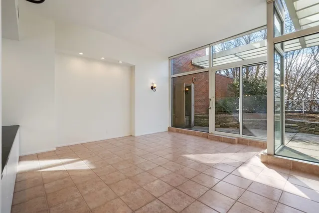 a view of an empty room with wooden floor and windows