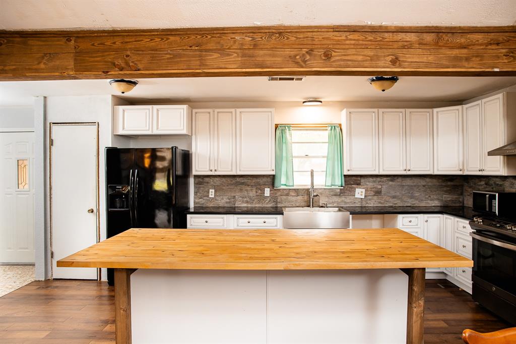 a kitchen with stainless steel appliances kitchen island granite countertop a table chairs in it and wooden floor