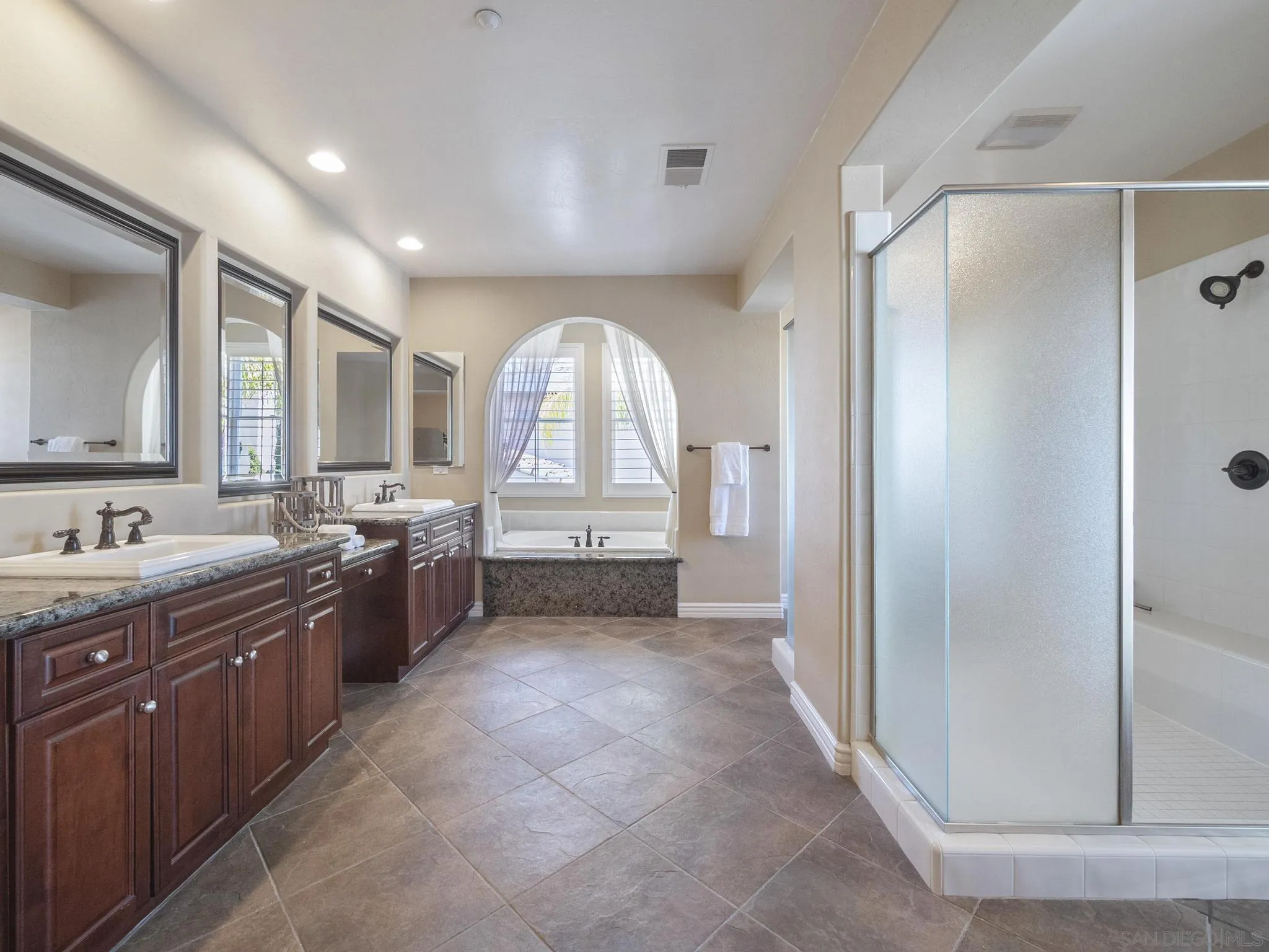 14636 Rio Rancho San Diego, CA 92127 - Photo 42 of 61 a large bathroom with a granite countertop tub a sink shower and mirror