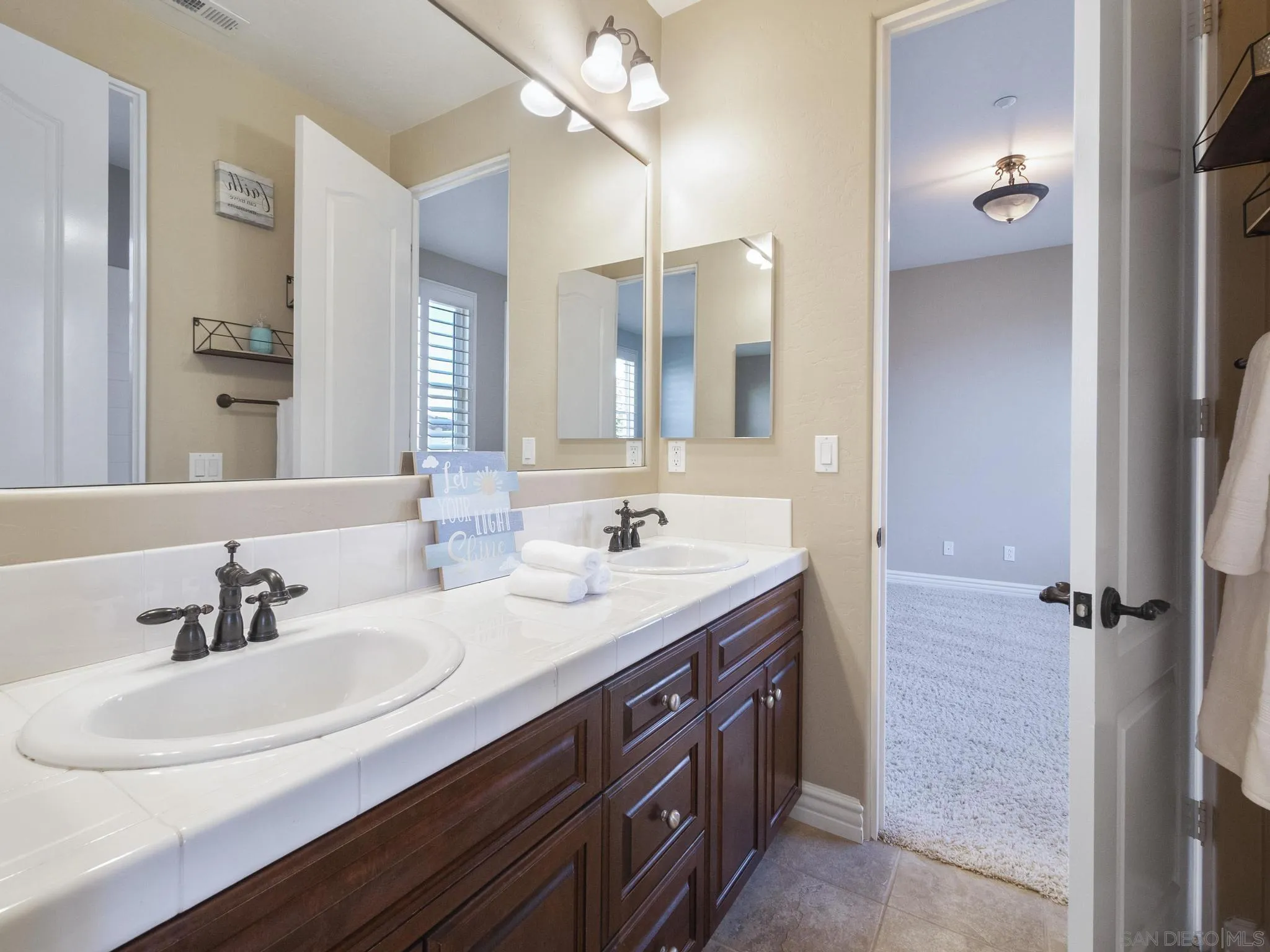 14636 Rio Rancho San Diego, CA 92127 - Photo 47 of 61 a bathroom with a double vanity sink a mirror and a shower