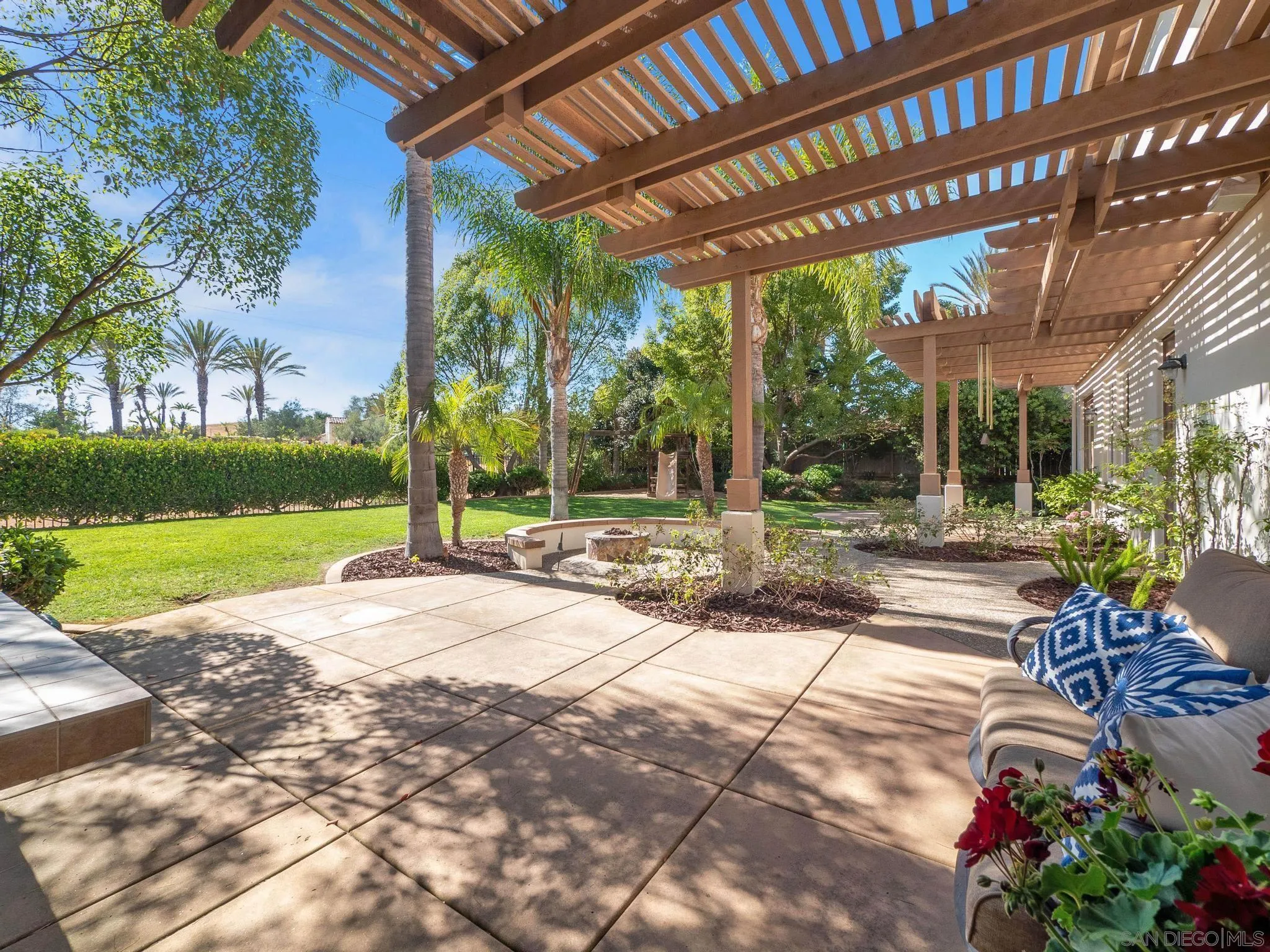 14636 Rio Rancho San Diego, CA 92127 - Photo 57 of 61 a view of a patio with a table and chairs under an umbrella with a big yard