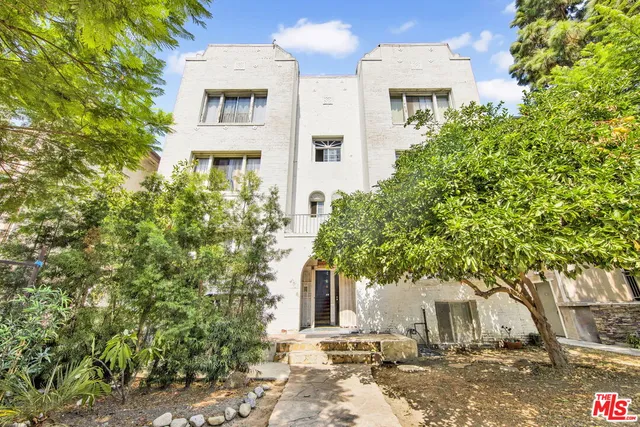 a view of a white house with a tree