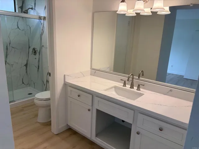 a bathroom with a double vanity sink toilet and shower