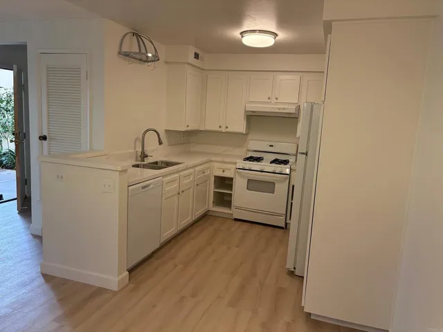 a kitchen with a sink a stove and cabinets