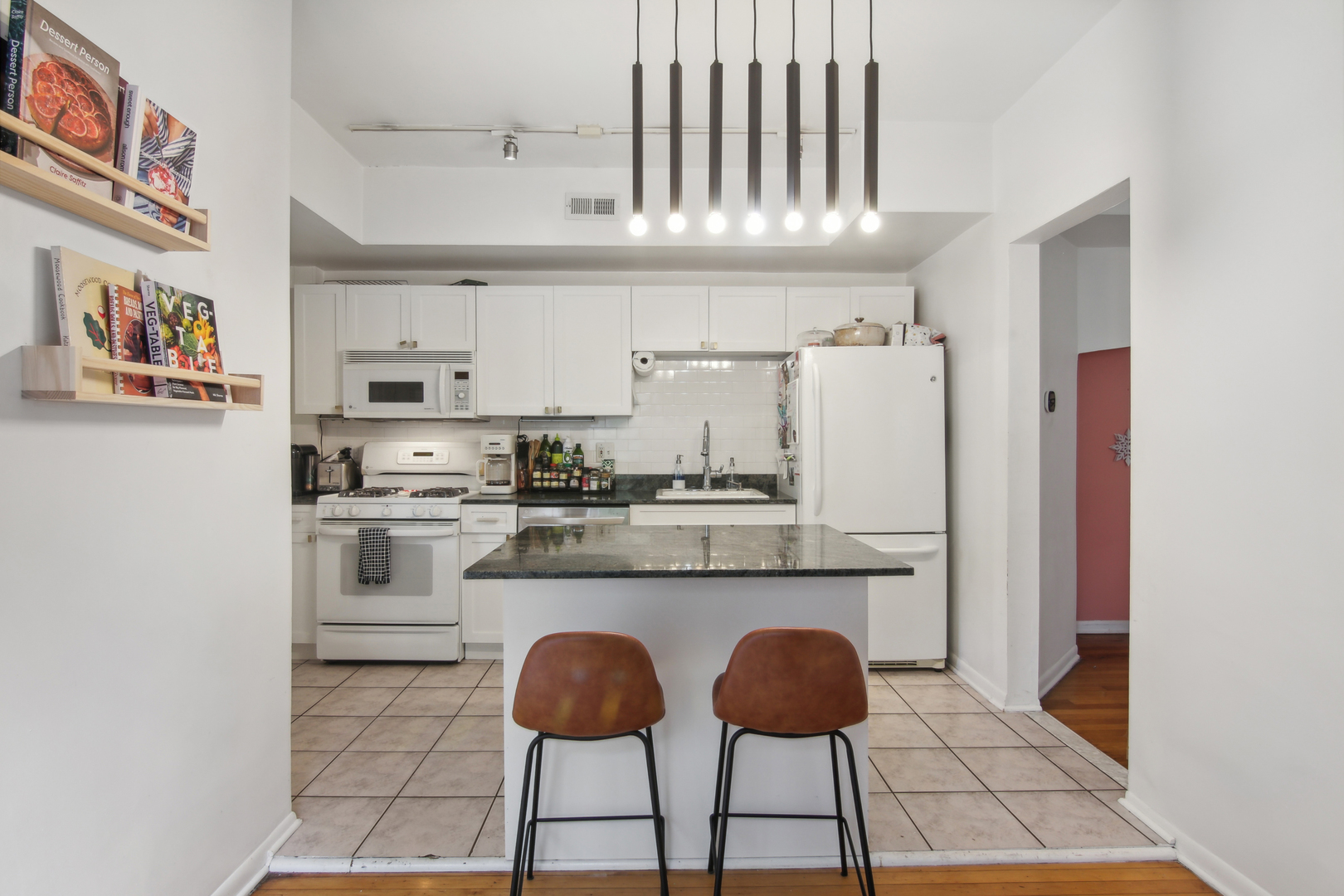 5683 North Ridge Avenue, Unit 2W Chicago, IL 60660 - Photo 11 of 23 a kitchen with stainless steel appliances granite countertop a stove a refrigerator and white cabinets with wooden floor