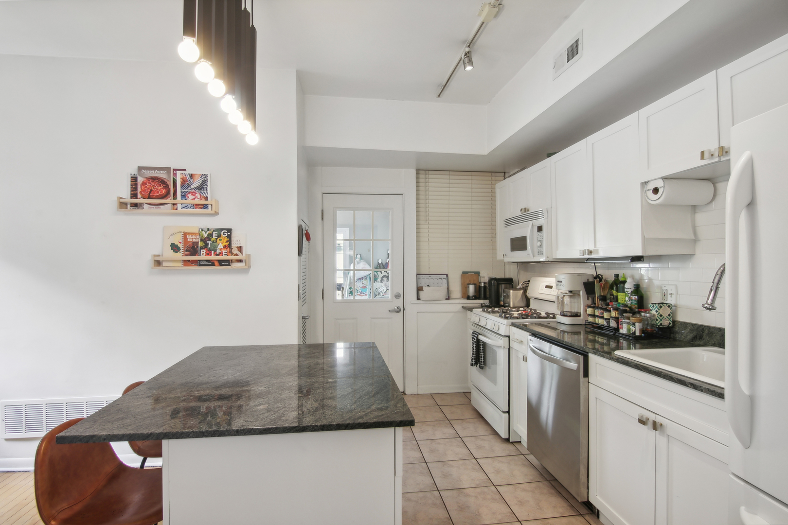5683 North Ridge Avenue, Unit 2W Chicago, IL 60660 - Photo 12 of 23 a kitchen with stainless steel appliances granite countertop a sink stove and cabinets