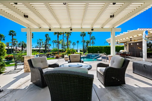 a view of a patio with couches and a table and chairs with garden view