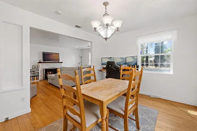 a view of a dining room with furniture a chandelier and wooden floor