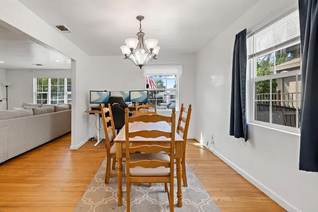 a view of a dining room with furniture a chandelier and wooden floor