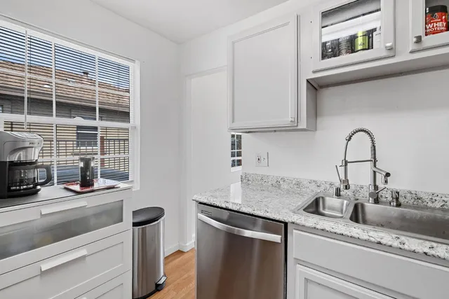a kitchen with granite countertop a sink and a stove