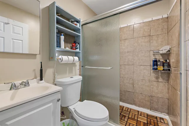 a bathroom with a sink a toilet and shower