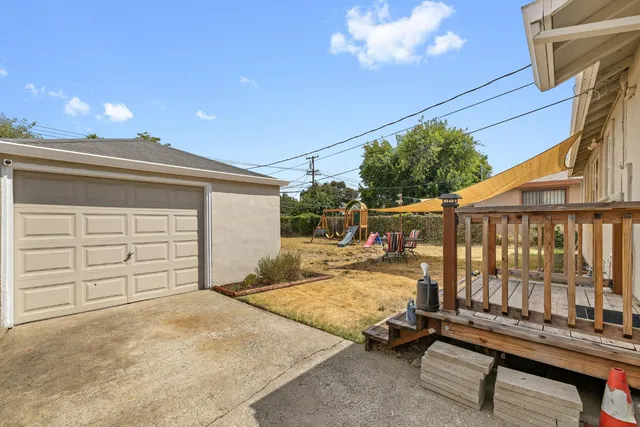a view of a chair and table in the back yard of the house