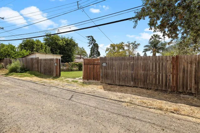 a view of a entrance gate of the house and trees