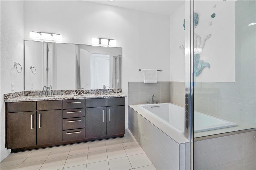 1101 Ivean Pearson Road, Unit A102 Lago Vista, TX 78645 - Photo 13 of 31 Bathroom with a garden tub, double vanity, light tile patterned floors, and a shower stall