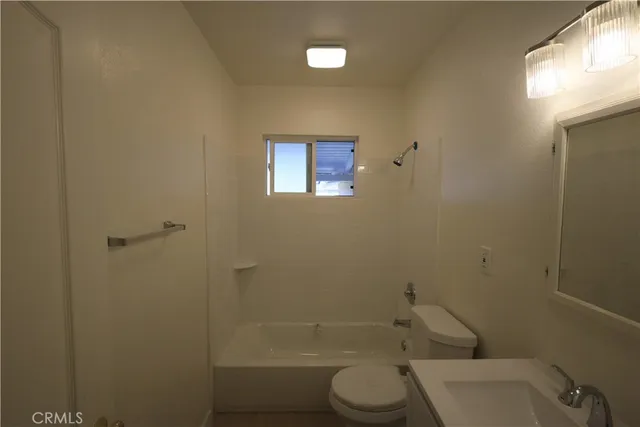 a white toilet sitting next to a bath tub