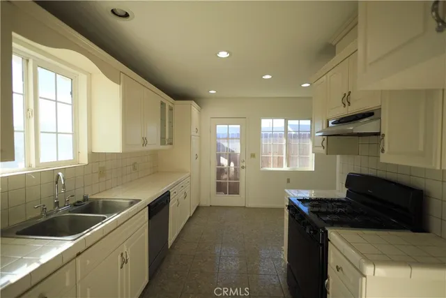 a kitchen with a sink stove top oven and refrigerator