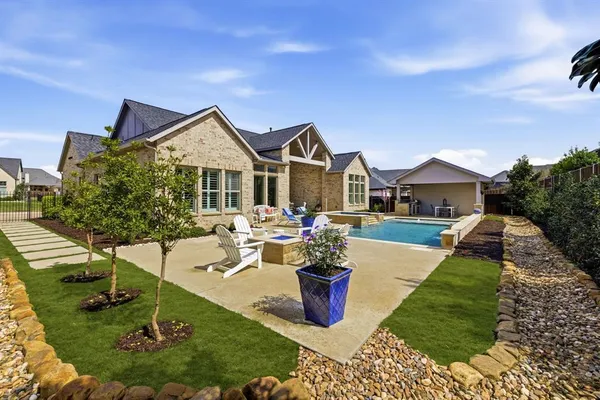 a view of a house with backyard sitting area and garden