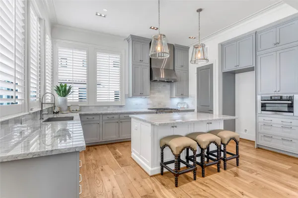 a large kitchen with granite countertop a stove a sink a dining table and chairs
