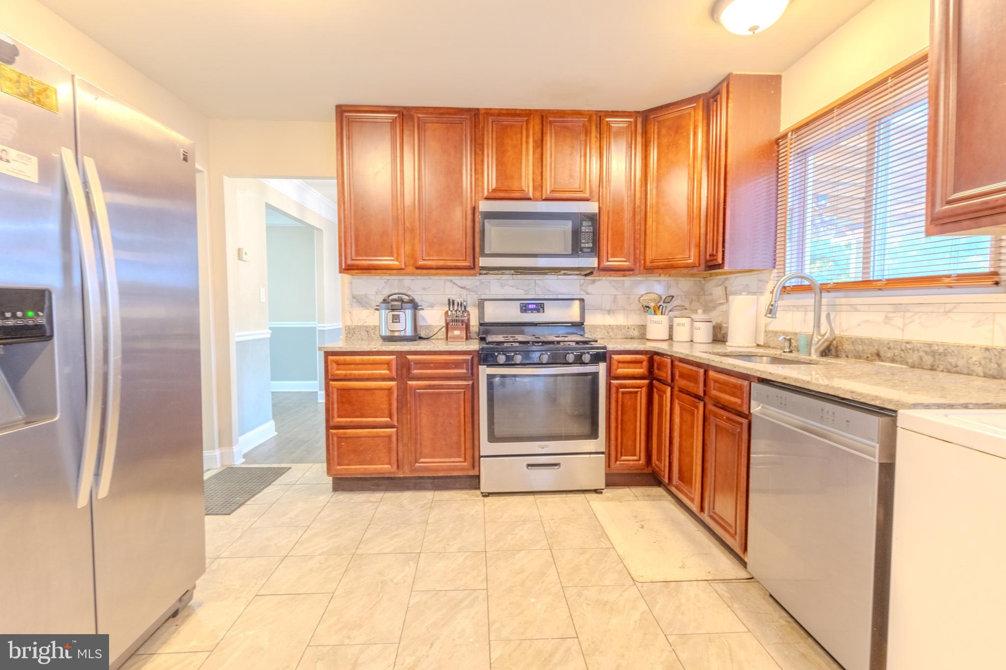 2106 North Rolling Road Windsor Mill, MD 21244 - Photo 11 of 26 a kitchen with stainless steel appliances granite countertop a stove a sink and a refrigerator