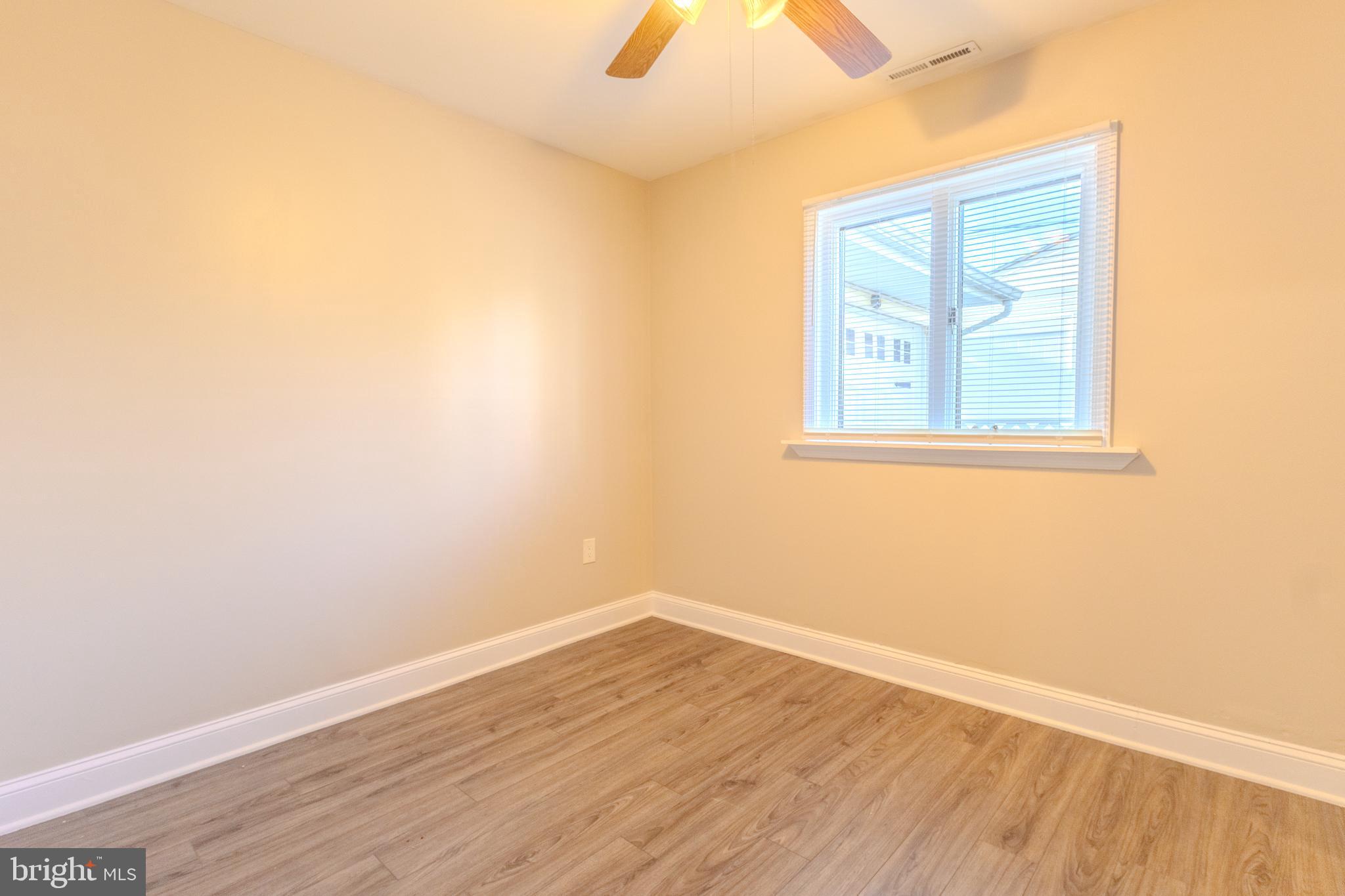 2106 North Rolling Road Windsor Mill, MD 21244 - Photo 13 of 26 an empty room with wooden floor and windows