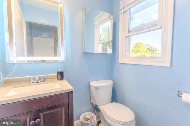 a bathroom with a toilet a sink and a window