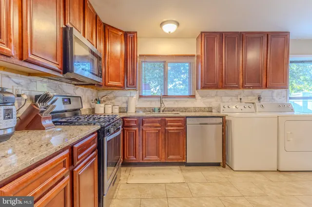 a kitchen with stainless steel appliances granite countertop a sink stove and cabinets