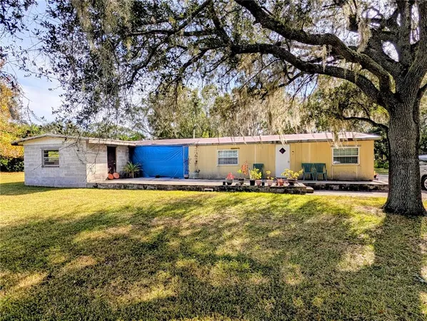 a view of a house with a yard and tree s