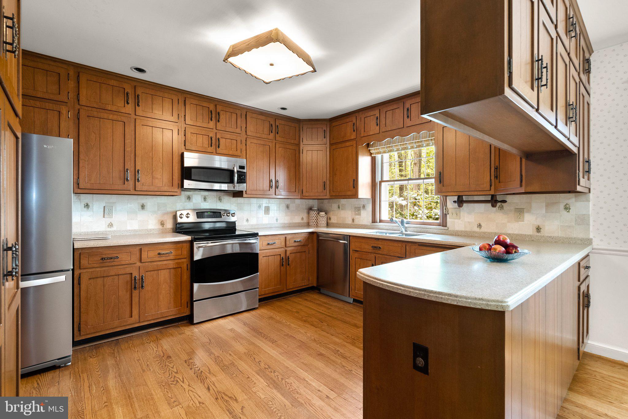 4811 Olney Laytonsville Road Olney, MD 20832 - Photo 11 of 63 a kitchen with stainless steel appliances granite countertop a sink dishwasher stove and microwave oven