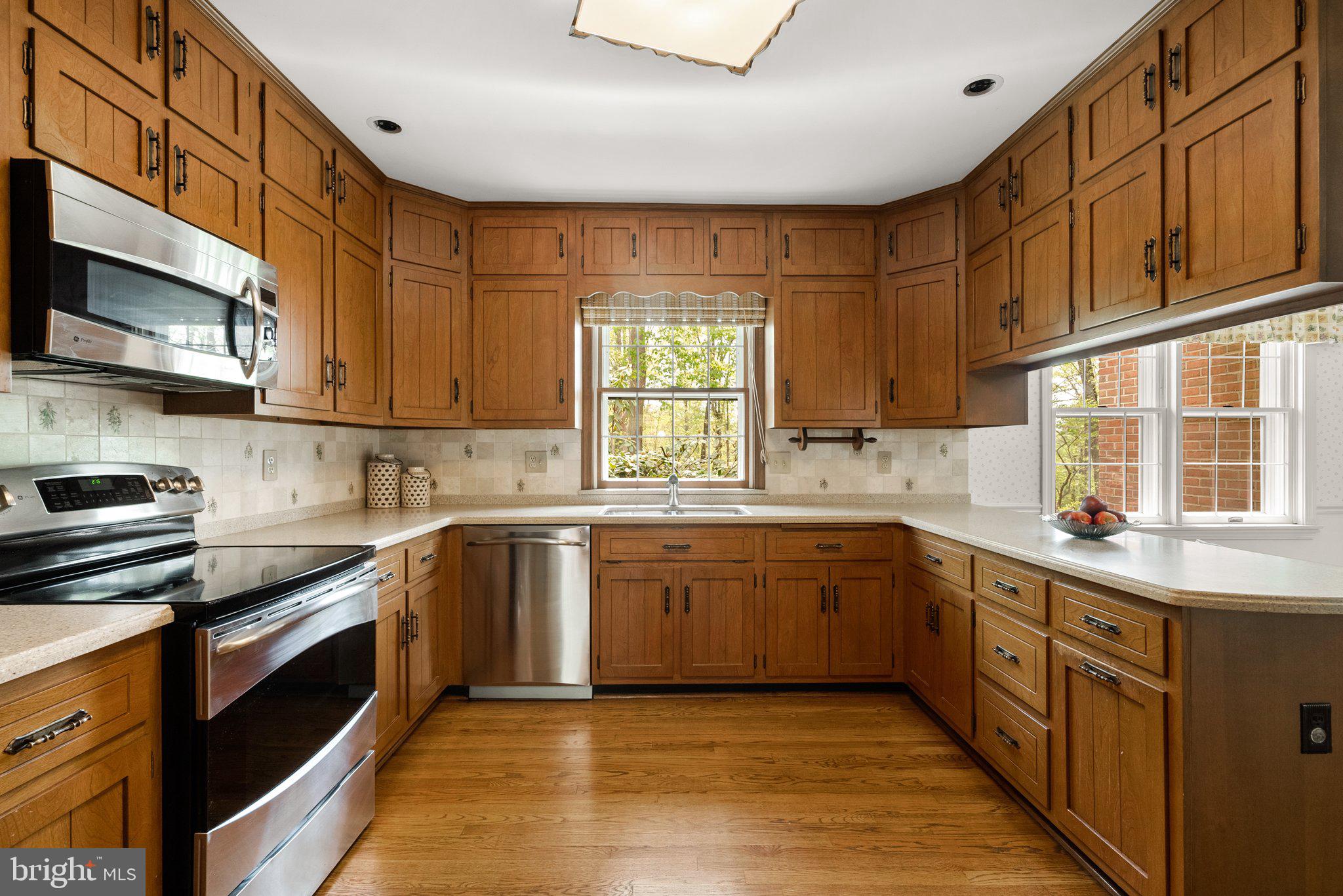 4811 Olney Laytonsville Road Olney, MD 20832 - Photo 12 of 63 a kitchen with stainless steel appliances granite countertop a sink and stove top oven