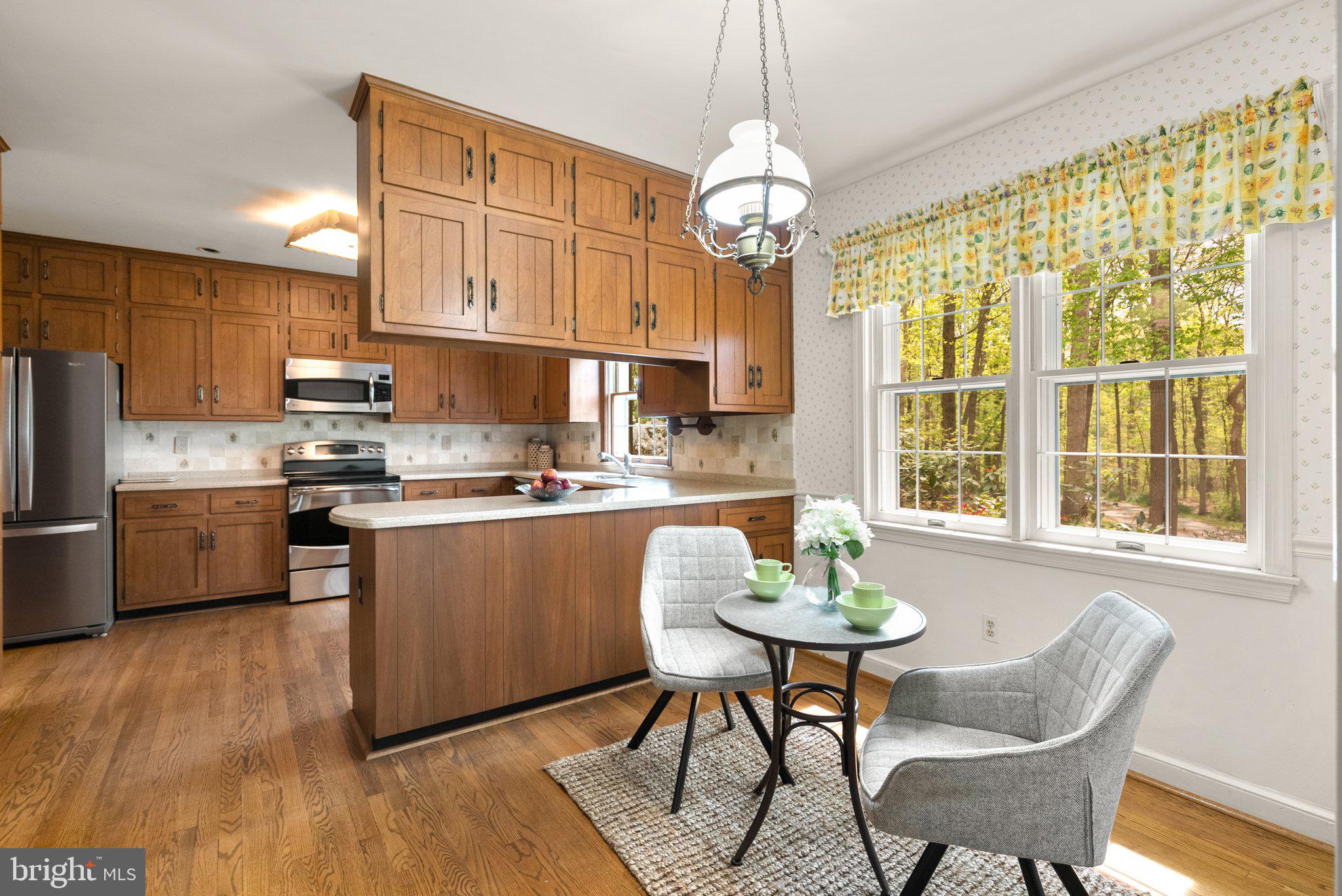 4811 Olney Laytonsville Road Olney, MD 20832 - Photo 15 of 63 a kitchen with stainless steel appliances granite countertop a stove a refrigerator a sink dishwasher a dining table and chairs with wooden floor