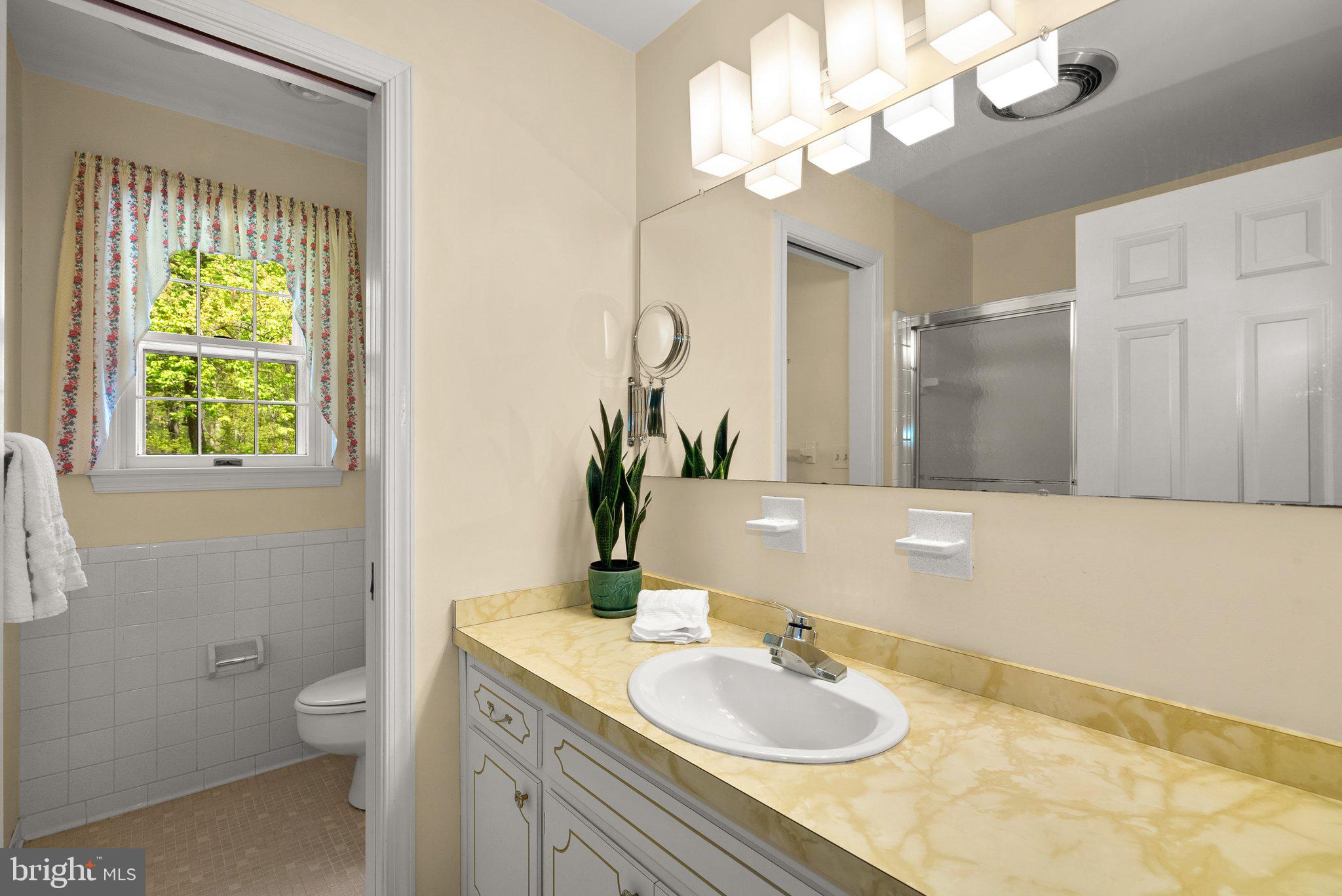 4811 Olney Laytonsville Road Olney, MD 20832 - Photo 38 of 63 a bathroom with a granite countertop toilet a sink and a mirror