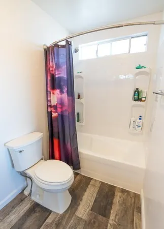 a white toilet sitting next to a bath tub