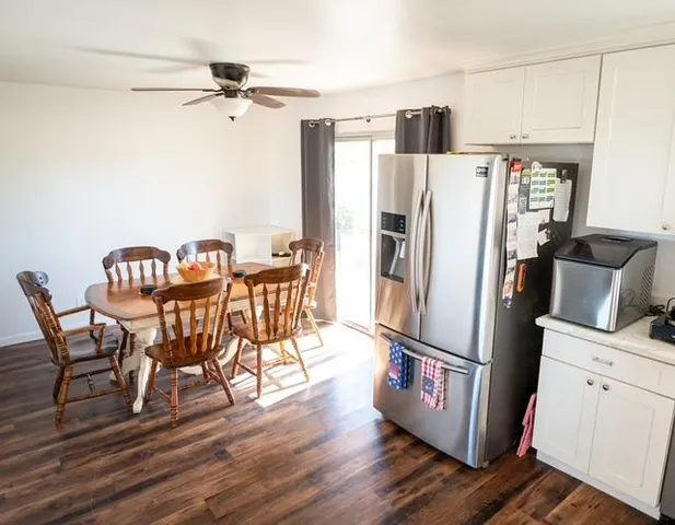 a view of a dining room with furniture a rug and wooden floor