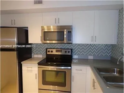 a kitchen with a sink stove and microwave
